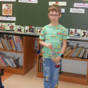 Otwórz zdjęcie - Uśmiechnięty chłopiec trzymający w dłoni zakładkę - super czytelnik klasy ID