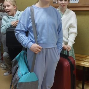 Otwórz zdjęcie - Trzy uśmiechnięte dziewczyny spakowane w walizki i torbę sportową.