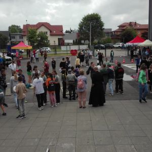 Otwórz zdjęcie - Uczniowie i nauczyciele zebrani na placu przed szkołą.