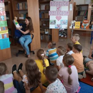 Otwórz zdjęcie - Mama jednego z uczniów czyta książkę dzieciom w towarzystwie pacynki.