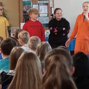 Otwórz zdjęcia - Grupa uczniów wraz z Joanną Olech wybierają osobę najbardziej przypominającą Miziołka.