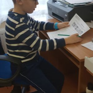 Otwórz zdjęcie: Uczeń siedzący w ławce, rozwiązujący zadanie.