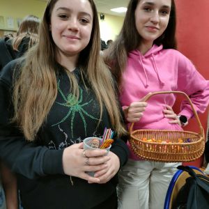 Otwórz zdjęcie: Dwie wolontariuszki trzymają koszyk z cukierkami.