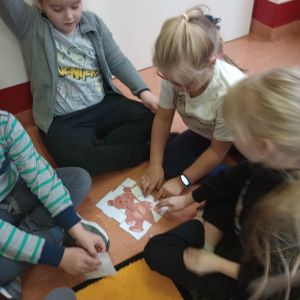 Otwórz zdjęcie: Chłopiec i dziewczynka układają puzzle z  misiem.