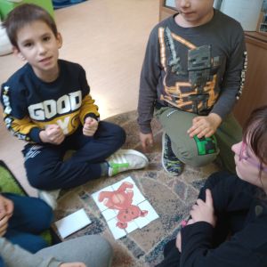 Otwórz zdjęcie: Dwóch chłopców którzy ułożyli puzzle z misiem.