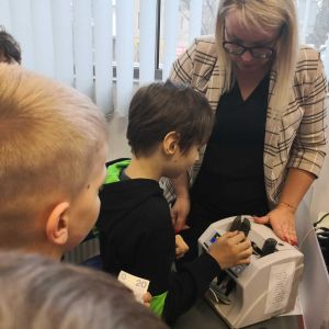 Otwór zdjęcie - Uczniowie oglądają maszynkę do liczenia pieniędzy.