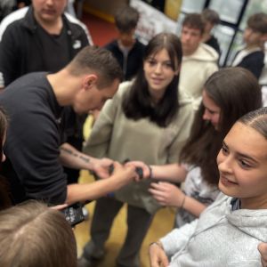 Otwórz zdjęcie - Rymcerze po spotkaniu z młodzieżą rozdają autografy, wpisując się markerami na rękach.
