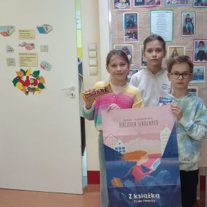 Otwórz zdjęcie - Troje uczniów trzymających w dłoniach plakat.