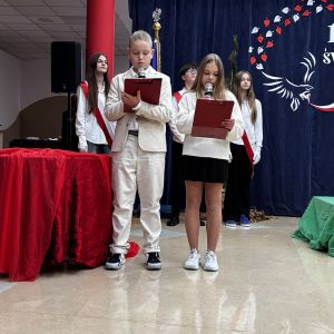 Otwórz zdjęcie - Chłopiec i dziewczyna ubrani w stroje galowe prowadzący apel.