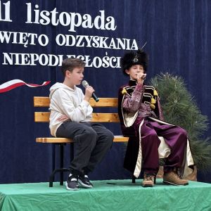 Otwórz zdjęcie - Chłopiec oraz uczeń przebrany za szlachcica siedzący na ławce.