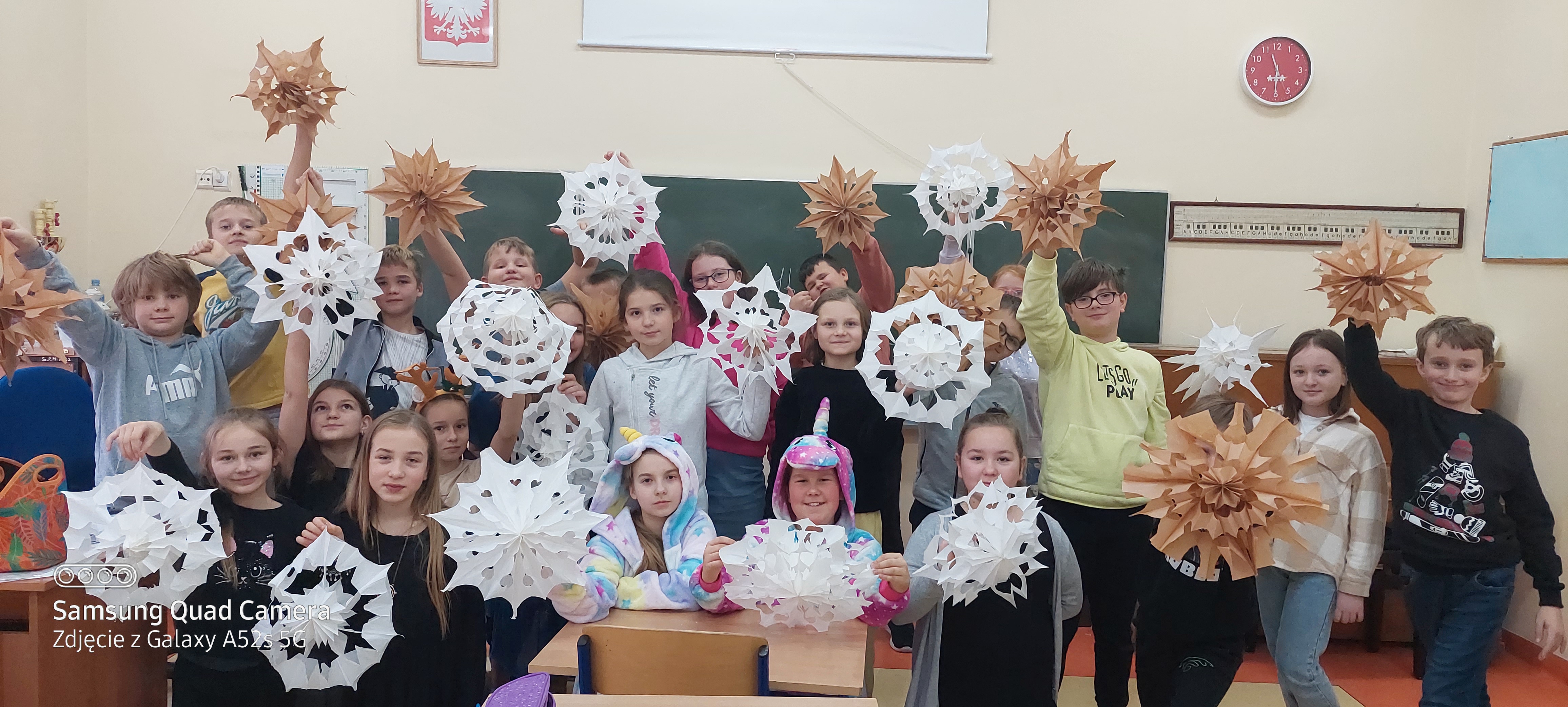 Zdjęcie grupowe uczniów klasy 4b trzymających swoje papierowe gwiazdy.