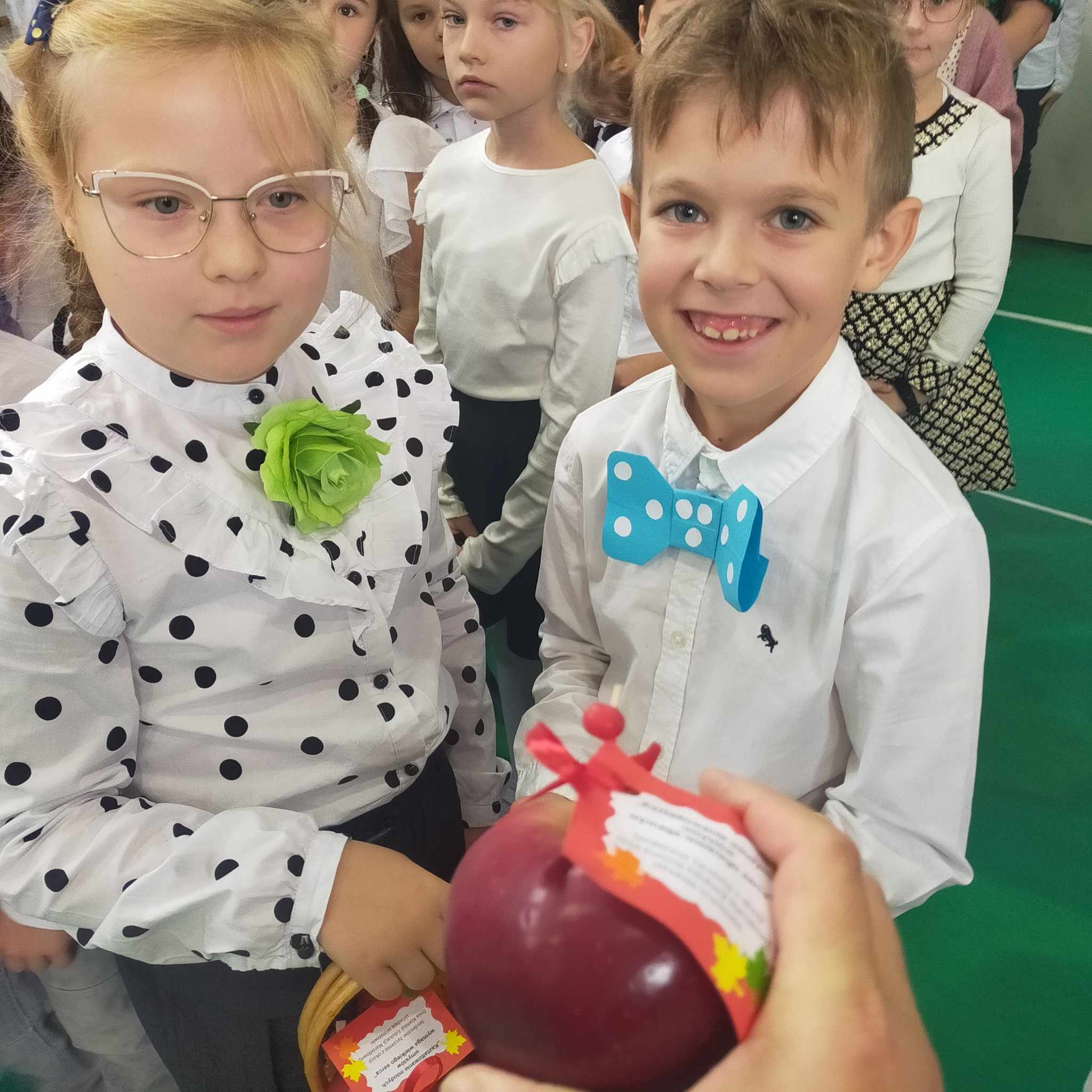 Chłopiec i dziewczynka trzymający w dłoniach jabłko.