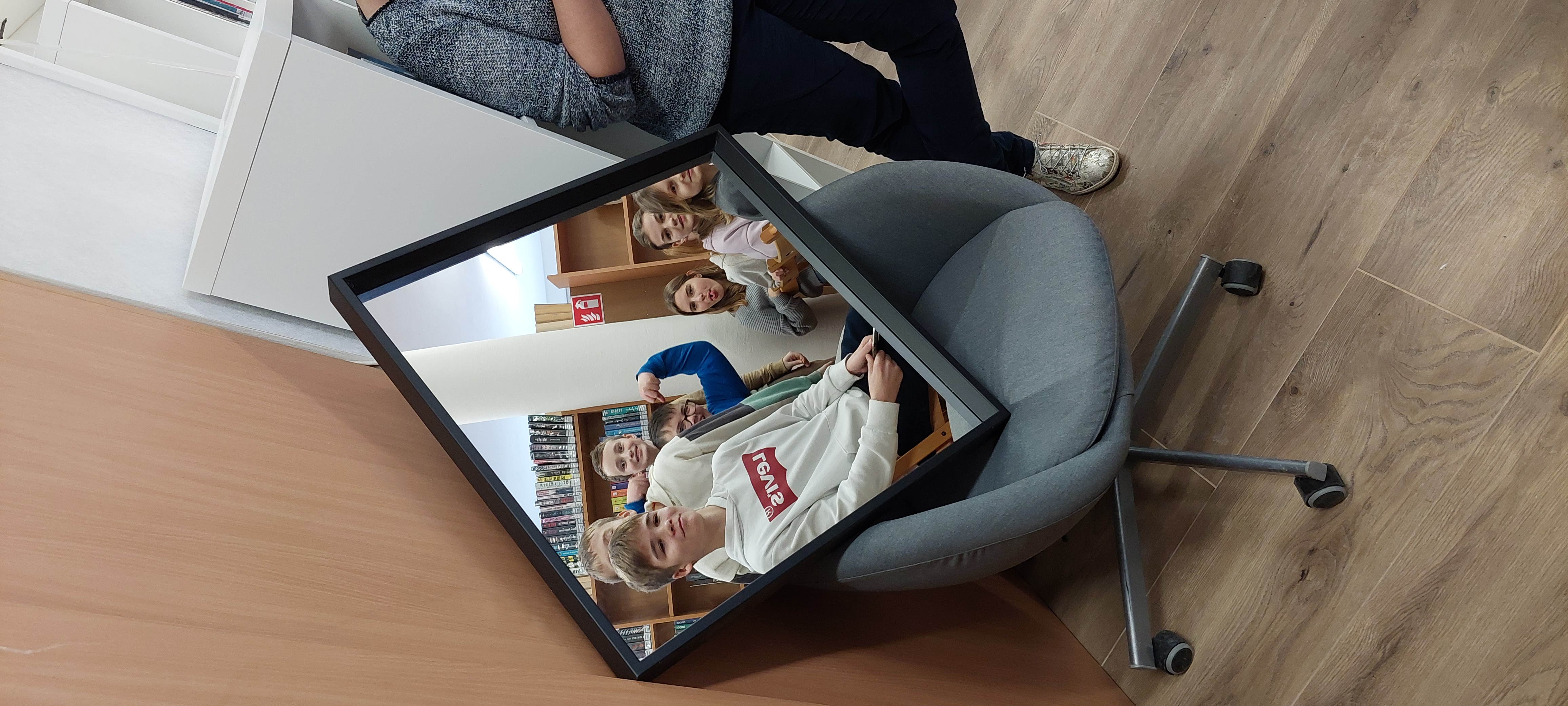 Zdjęcie uczniów odbijających się w lustrze ze śmiesznymi minami.