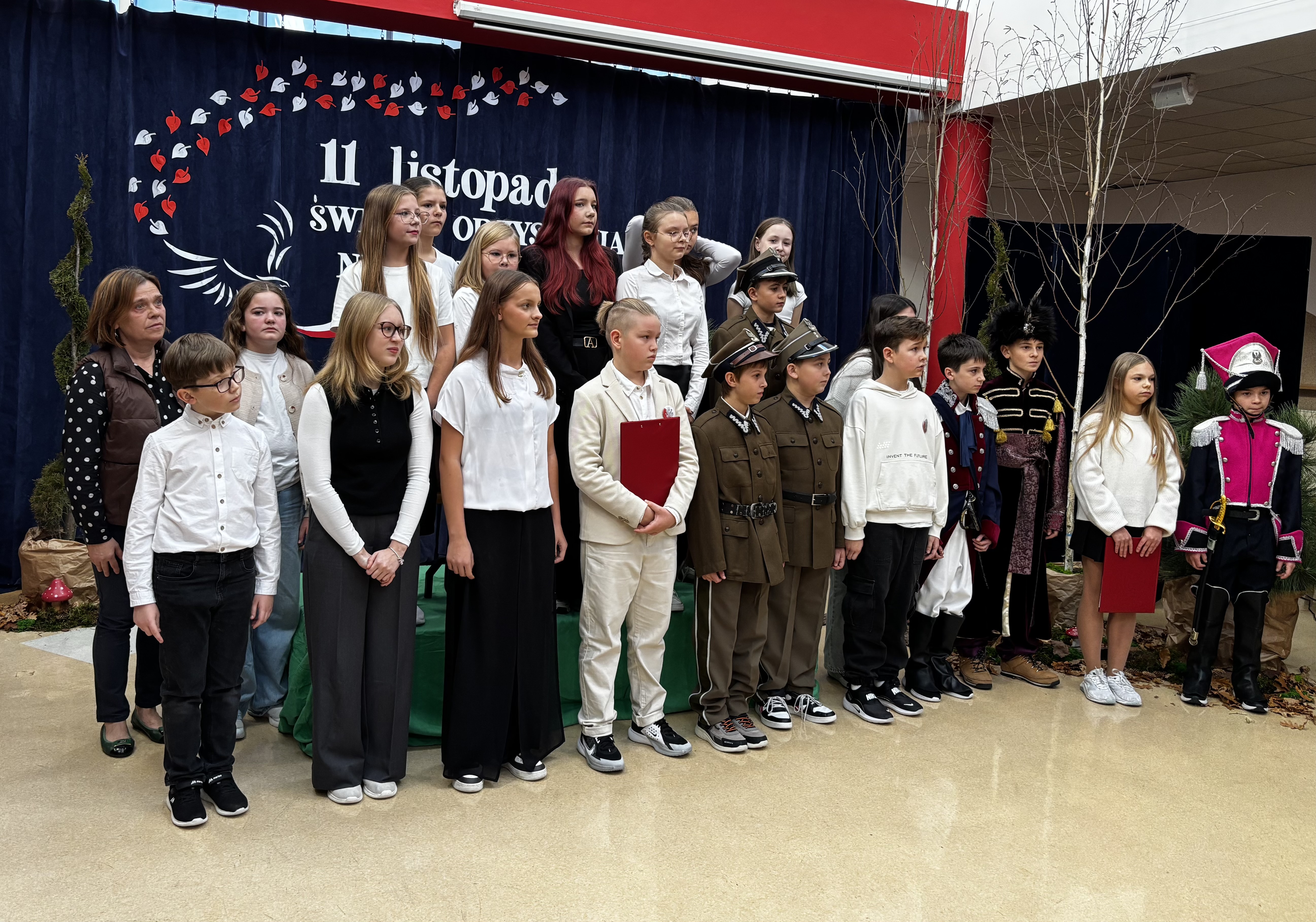 Wszyscy aktorzy i ich opiekunka na scenie z panią dyrektor.